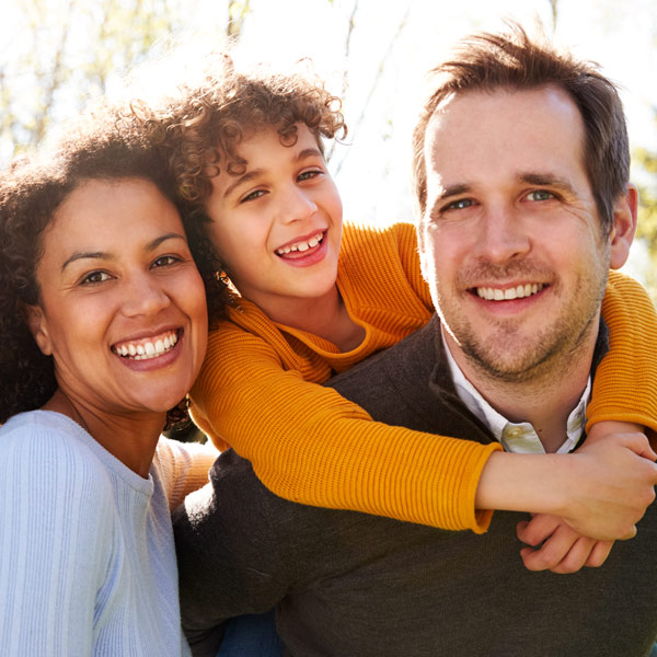family smiling outdoors