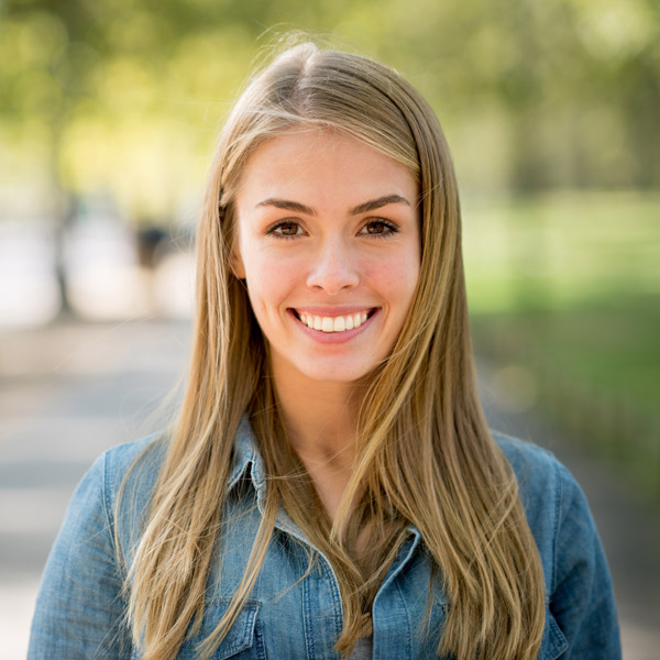 young blonde woman in jean jacket smiling
