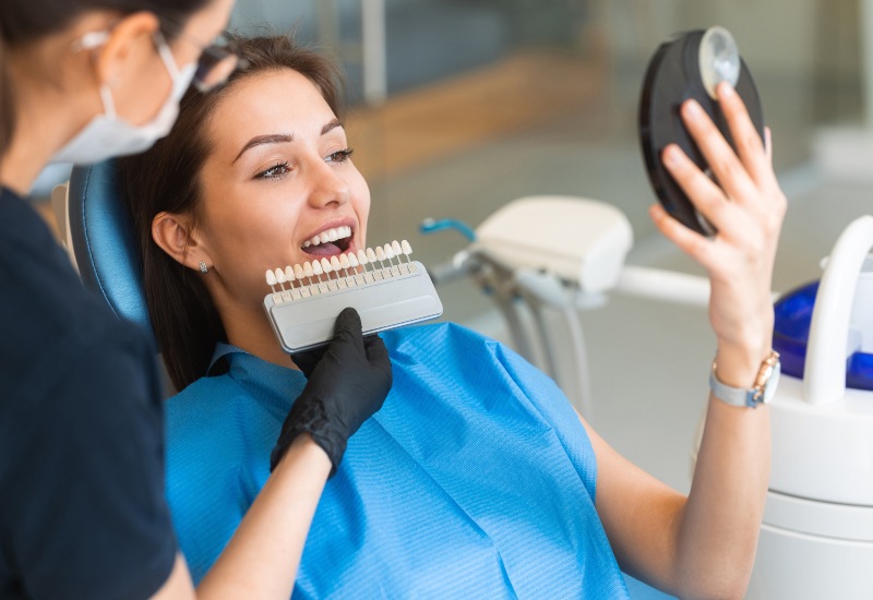 A dental professional guides a patient using a shade guide for Dental Veneers in Terre Haute, IN