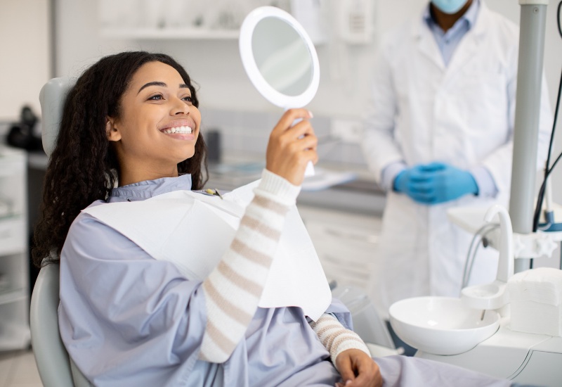 A patient admiring the results after teeth whitening with a dentist in a clinic in Terre Haute, IN